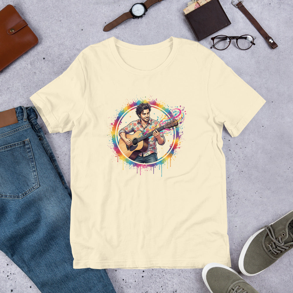 Beige t-shirt with a colorful graphic of a person playing guitar on a gray surface with jeans, shoes, and accessories.